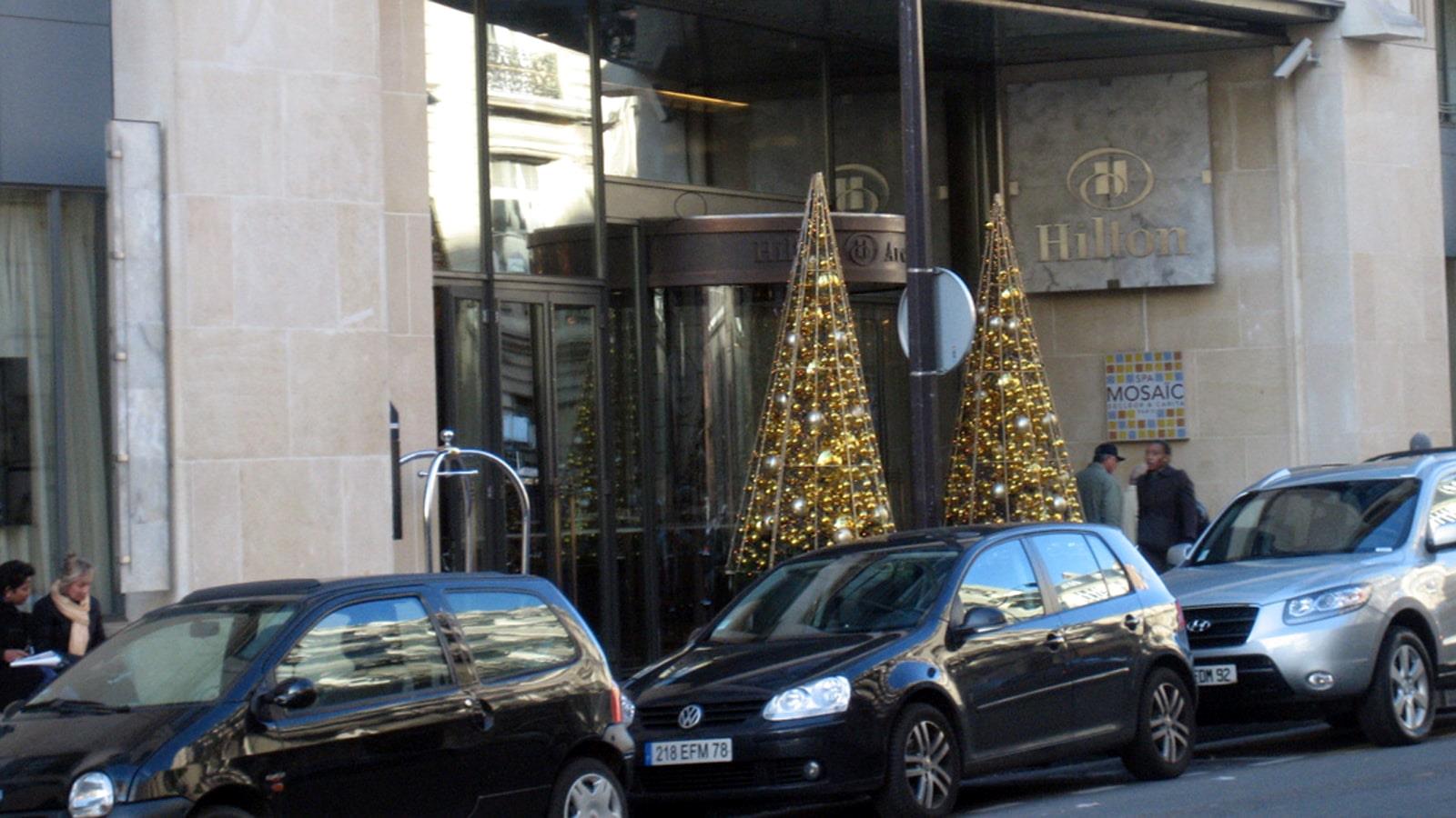 Two Christmas trees with golden decoration at Hilton Hotel entrance