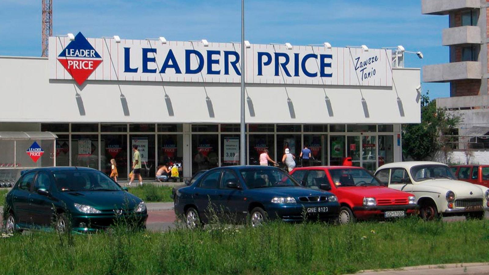 Four private cars parked in front of Leader Price supermarket