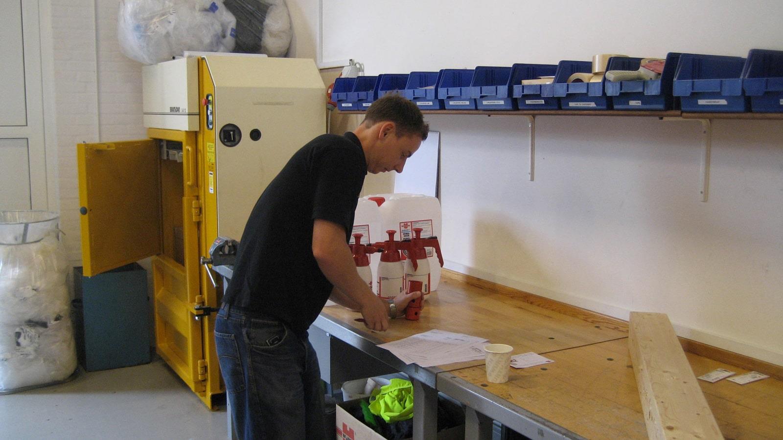 Würth employee works at packing table next to Bramidan baler